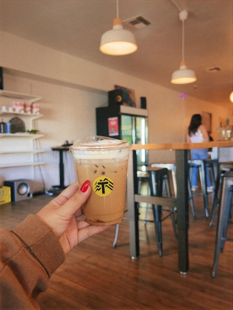 Iced coffee with a yellow Tamosan sticker, photographed in the Scottsdale lounge.